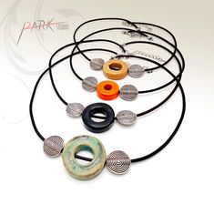 an assortment of necklaces and rings are displayed on a white background with the words dark studio written below them