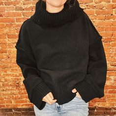 This Ebony Chunky Turtleneck Cozy Sweater Provides Both Style And Comfort With A Solid Turtleneck Design, Raw Seam Detail, And Drop Shoulder Fit. The Ribbed Hem Adds A Touch Of Texture While The Long Sleeves Keep You Warm. Stay Cozy And Chic With This Must-Have Winter Top. Fit Oversized Model Is 5'2 Wearing A Small Black Cozy Funnel Neck Top, Cozy Black Funnel Neck Top, Cozy Black Top For Cold Weather, Black Slouchy Sweater For Winter, Cozy Black Chunky Knit Top, Y2k High Fashion, High Fashion Denim, Chunky Turtleneck, Winter Top