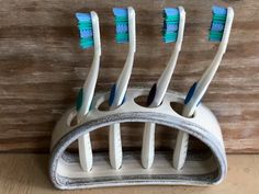 four toothbrushes in a holder on a wooden surface