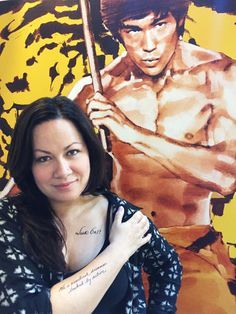 a woman holding a baseball bat in front of a wall with a painting on it