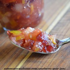 a spoon full of jelly sitting on top of a wooden table