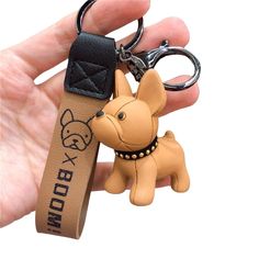 a person holding a keychain with a dog on it's front and back sides