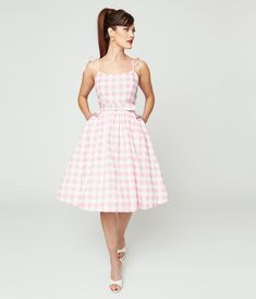 An adorably retro piece from Unique Vintage, the Bobbie Dress is crafted in a sensational lightweight, woven cotton, making it a standard frock in every vintage lover’s wardrobe. Cast in a classic mid century light pink & gingham silhouette, this darling 1950s design boasts a princess seamed bodice, secured by adjustable spaghetti straps that provide a fabulous fit to your feminine form. The seamed waist centers and cinches your figure with a matching belt, while the dramatic swing skirt cascades to the knees, complete with side pockets for fantastic function! <br>Available in sizes XS-5X while supplies last. Mid Century Light, Uv Clothing, Vestidos Color Rosa, 1950s Design, Womens Vintage Dresses, Maxi Robes, Pink Gingham, Gingham Dress, Vintage Lover