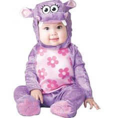 a baby in a purple monster costume sitting on the ground with its eyes wide open