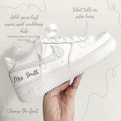 a hand holding up a white nike air force shoe with the words mr and mrs written on it