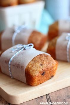 several pieces of bread wrapped in paper on a cutting board with blue ribbon around the edges