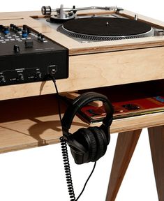 a turntable with headphones on it sitting next to a record player and mixer