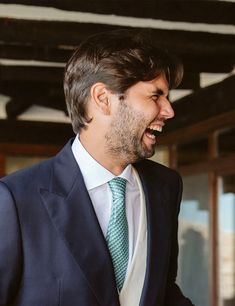 a man in a suit and tie laughing