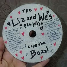 a hand holding a white disc with writing on it that says the lizard and we's playlist