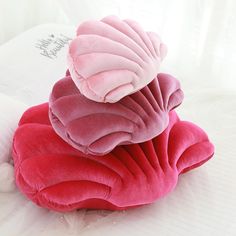 three pillows stacked on top of each other in the shape of heart shaped cushions, one pink and one red