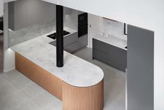 an aerial view of a modern kitchen with marble counter tops and wooden accents on the island