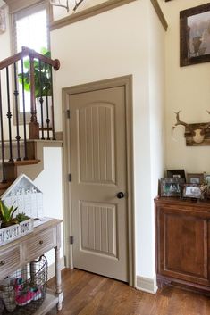 an entryway with wooden floors and white walls