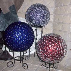 three decorative balls sitting on top of a fireplace