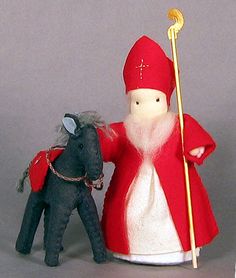 a small toy horse next to a figurine wearing a red cape and holding a staff