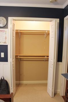 an empty bedroom with blue walls and white closet doors open to reveal a walk - in closet