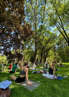 a group of people doing yoga in the park on their stomachs and arms up