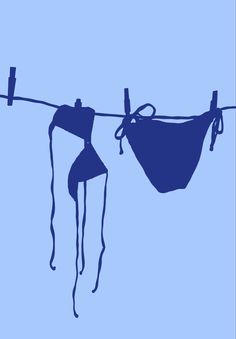 two bikinis hanging on a clothes line against a light blue background with no one in it