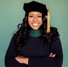 a woman wearing a graduation cap and gown with her arms crossed in front of her chest