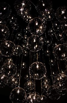 a large chandelier made out of glass balls and lights hanging from the ceiling