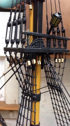 a close up of a model ship with ropes and chains on it's sides