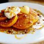 a white plate topped with sliced oranges and whipped cream on top of oatmeal