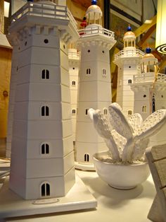 several white lighthouses sitting on top of a table next to a bowl filled with food