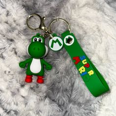 a green keychain with an image of a cartoon character and the word super mario on it