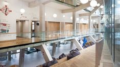 the inside of a building with glass walls and wooden flooring is pictured in this image