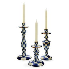 three blue and white checkered candlesticks with one candle on the other side