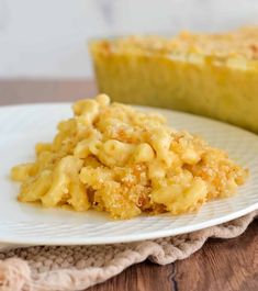 a white plate topped with macaroni and cheese next to a slice of pie