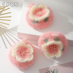 three pieces of pink and white yarn on top of a table next to a pineapple