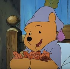 winnie the pooh is holding leaves in her hands and smiling at someone else who is looking on