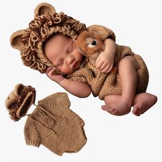 a newborn baby wearing a lion outfit and holding a stuffed teddy bear in it's arms