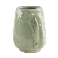 a green ceramic vase with an elephant design on it's front and side rim