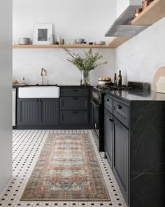 a black and white kitchen with an area rug