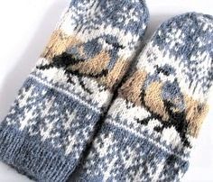 two blue and yellow mittens sitting next to each other on top of a white surface