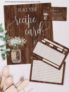 there are some wooden utensils next to the recipe cards and spoons on the table