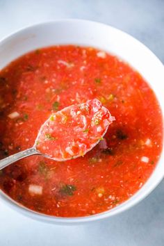 a white bowl filled with soup and a spoon