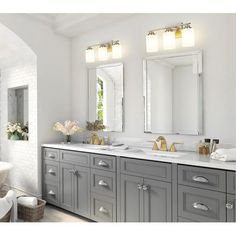 a large bathroom with two sinks and mirrors on the wall, along with a bathtub