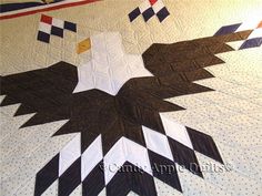 an eagle quilt is displayed on the bed