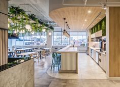 the interior of a restaurant with tables, chairs and plants hanging from the ceiling over the counter