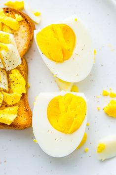 two halves of bread with hard boiled eggs on them sitting on a white plate next to sliced bananas