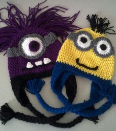 two crocheted hats with googly eyes and fringes on the sides, one is purple and one is yellow