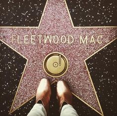 a person standing next to a star on the hollywood walk of fame with their feet up