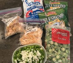 several bags of food sitting on top of a counter next to some chips and vegetables