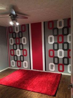 a living room with red carpet and grey wallpaper on the walls, along with an area rug