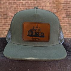 "Drive", mesh adjustable snapback hat Does your kid love tractors? In pairing original artwork with a leather patch and high quality craftsmanship, the hat is perfect for all your days on the farm! **SIZING INFO** Fits 18"-21" head circumference and have a mesh backing. The adjustable straps fit head circumference of 18-21 inches and fit best on ages three and up. Measure your child's head circumference to be sure! Every child is different. WHAT MAKES US DIFFERENT - We are a family company, woman and mom owned! - Our designs are all original artwork created from the inspiration we draw from our outdoor-loving kids! - Our clothing is hand-printed in small batches in our shop right in Western North Carolina. - Our clothing is made with a polyester/cotton blend that is SUPER SOFT and durable. Adjustable Trucker Hat With Leather Patch, Hat For Kids, Farm Kids, Bf Gifts, Farm Tractor, Kids Hats, Head Circumference, Leather Patches, Country Life