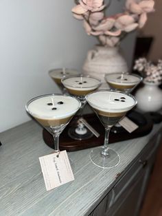 four martini glasses with chocolate toppings on a table