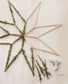 some sticks are laying on the floor next to plants and glue stick holders with needles sticking out of them