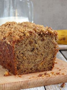 a loaf of banana bread sitting on top of a wooden cutting board